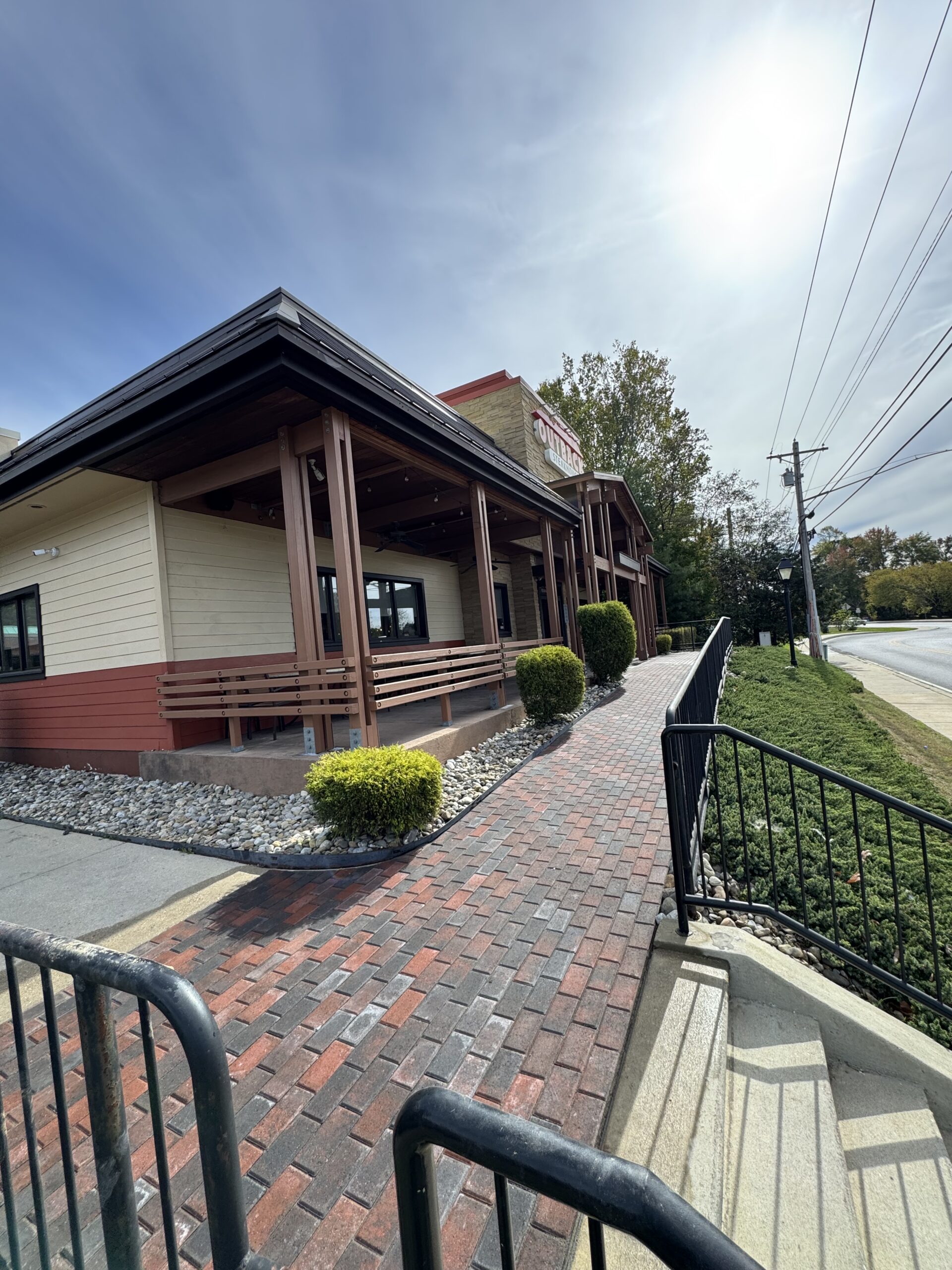 hardscape installation for a restaurant's sidewalk using red and black bricks.